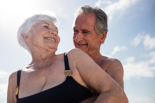 Gelukkig hoger paar omarmen op het strand