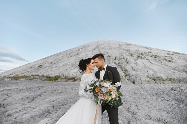 Gelukkig huwelijkspaar dat zich in openlucht over het mooie landschap met bergen bevindt