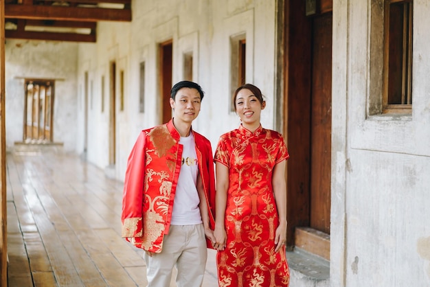 Gelukkig jong Aziatisch stel houdt van Chinese traditionele jurken - Rood is de hoofdkleur van het traditionele feest, inclusief bruiloft in China.