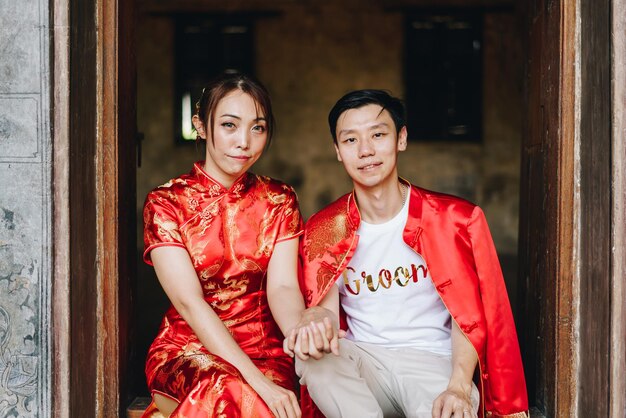 Gelukkig jong Aziatisch stel houdt van Chinese traditionele jurken - Rood is de hoofdkleur van het traditionele feest, inclusief bruiloft in China.