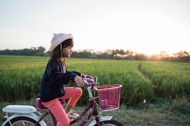 Gelukkig jong geitjemeisje die haar fiets berijden openlucht