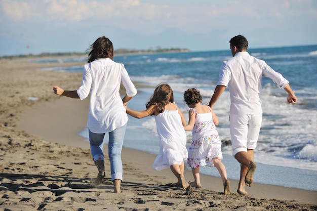 gelukkig jong gezin in witte kleding veel plezier op vakanties op het prachtige strand