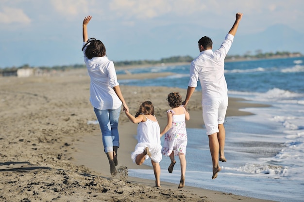 gelukkig jong gezin in witte kleding veel plezier op vakanties op het prachtige strand