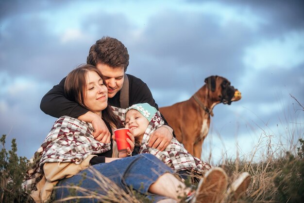 gelukkig jong gezin met een klein kind en een hond in de natuur