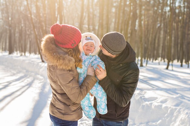 Gelukkig jong gezin met hun zoontje tijd buiten doorbrengen in het winterpark.