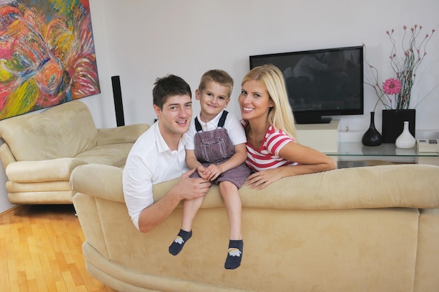 Gelukkig jong gezin met kinderen in lichte moderne woonkamer veel plezier en kijken naar grote platte lcd-tv