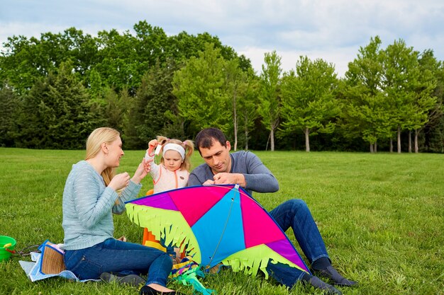 Gelukkig jong gezin met vliegeren in het park