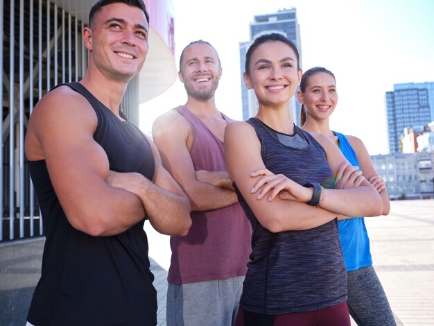 Gelukkig jong kaukasisch fitnessteam met gekruiste handen