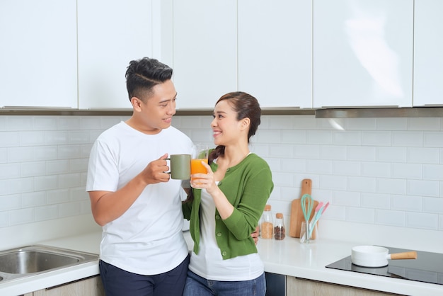 Gelukkig jong koppel dat zich in de keuken in hun huis bevindt.