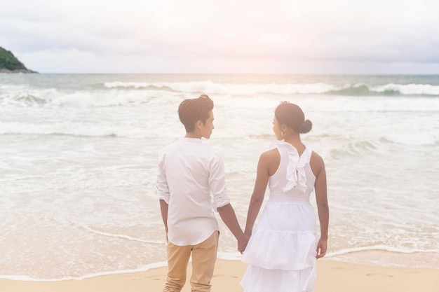 Gelukkig jong koppel dragen witte jurk op het strand op vakantie reizen romantisch huwelijksconcept