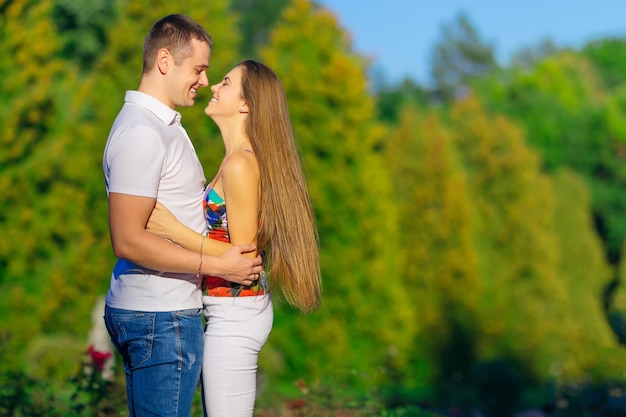 Gelukkig jong koppel knuffelen samen met hartstochtelijke liefde in een openbaar park paar verliefd romantisch