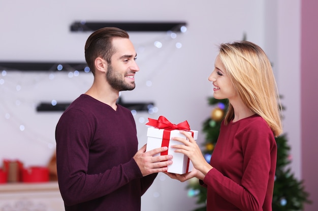 Gelukkig jong koppel met kerstcadeautjes thuis