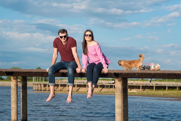 Gelukkig jong koppel wandelen op de pier aan het meer op een zonnige zomerdag