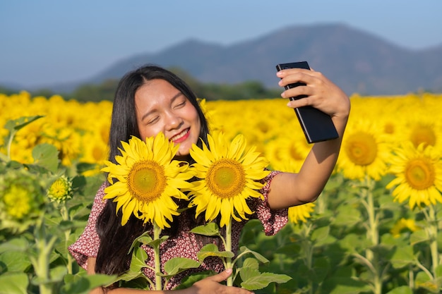Gelukkig jong meisje selfie met mooie zonnebloem en blauwe lucht