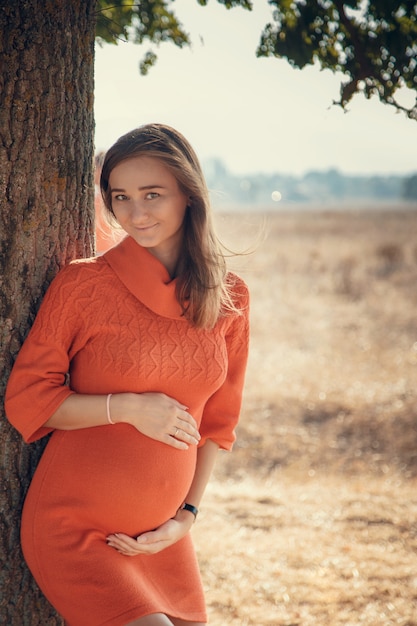 Foto gelukkig jong paar dat baby, zwangere vrouw met echtgenoot wat betreft buik verwacht.