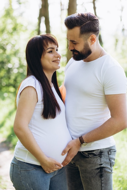 Gelukkig jong paar die baby in de zomerpark verwachten