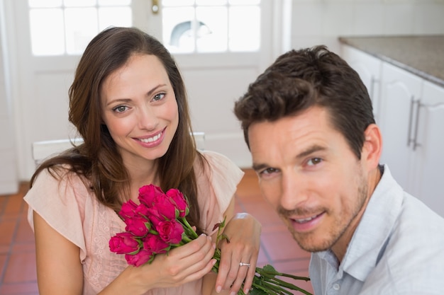 Gelukkig jong paar met bloemen thuis