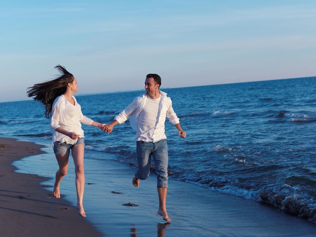 gelukkig jong romantisch verliefd stel veel plezier op het prachtige strand op een mooie zomerdag