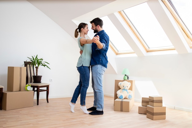 Gelukkig jong stel dansen en vieren hun allereerste dag in het nieuwe huis.