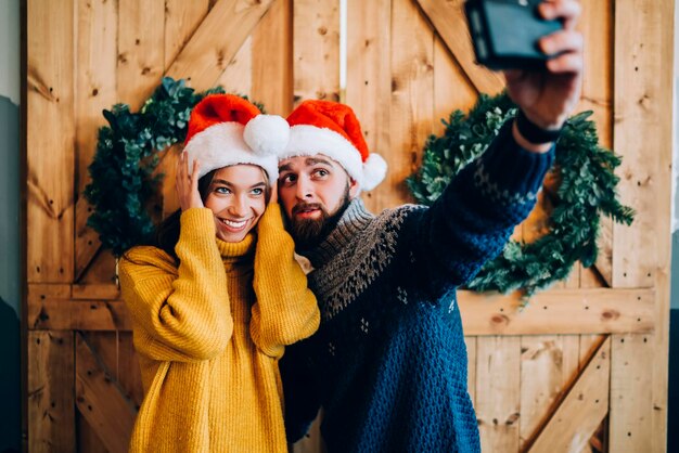 Gelukkig jong stel dat selfie neemt tijdens Kerstmis