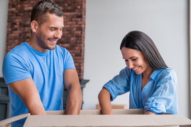 Gelukkig jong stel dozen uitpakken terwijl ze naar een nieuw huis verhuizen