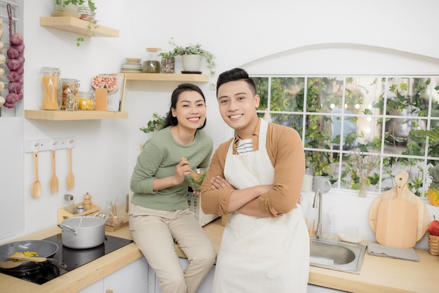 Gelukkig jong stel eten en praten in de keuken