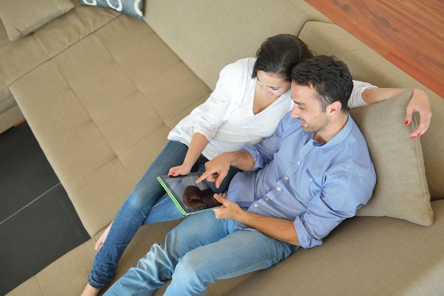 gelukkig jong stel in modern huis met behulp van tabletcomputer