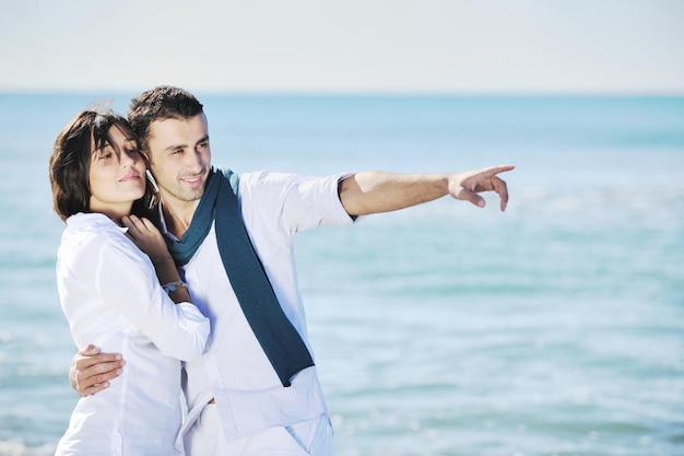 gelukkig jong stel in witte kleding heeft romantische recreatie en plezier op het prachtige strand tijdens vakanties