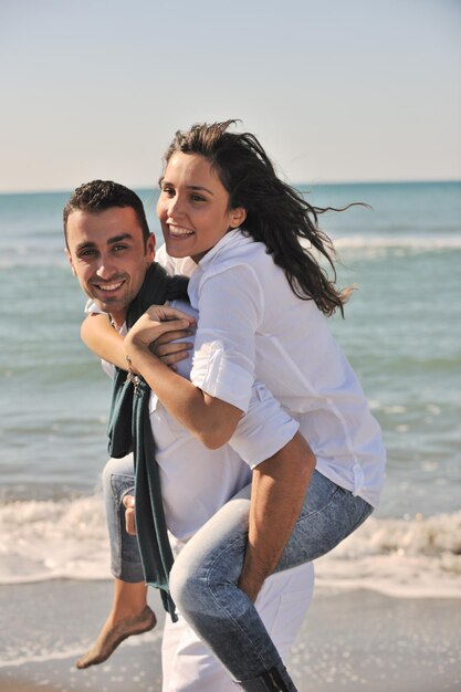 gelukkig jong stel in witte kleding heeft romantische recreatie en plezier op het prachtige strand tijdens vakanties