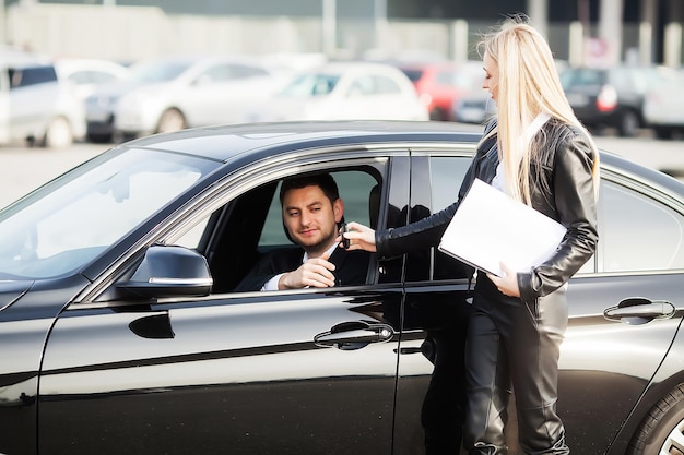 Gelukkig jong stel kiest en koopt een nieuwe auto voor het gezin