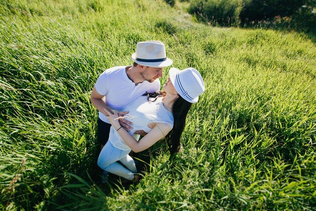 Gelukkig jong volwassen paar dat op het gras ligt Verliefde paar Vrijheidsconcept Levensconcept Romantisch liefdesverhaal Summertime