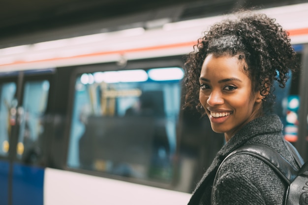 Gelukkig jong zwarte binnen het ondergrondse station dat op de trein wacht