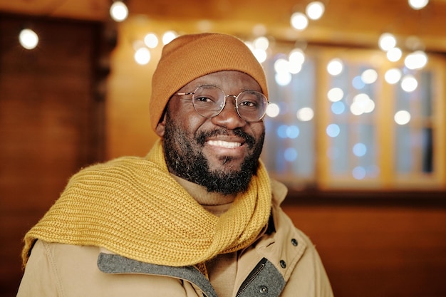 Gelukkig jonge Afro-Amerikaanse man in winterkleding en bril