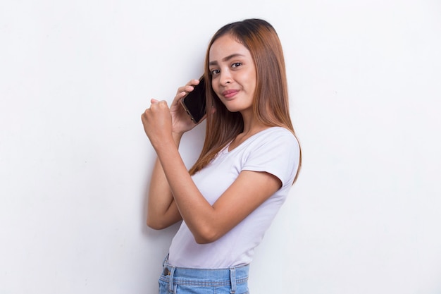 Gelukkig jonge Aziatische mooie vrouw met behulp van mobiele telefoon geïsoleerd op een witte achtergrond