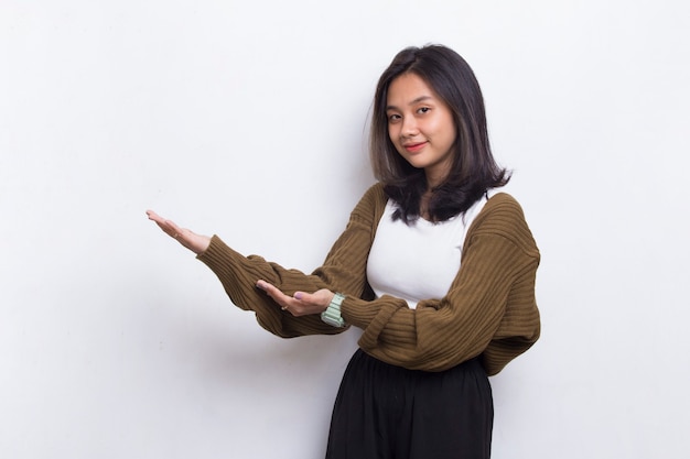 Gelukkig jonge Aziatische vrouw wijzend met de vingers naar verschillende richtingen geïsoleerd op een witte achtergrond