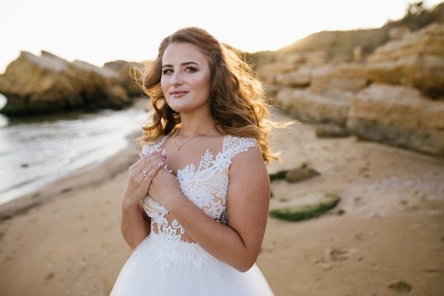 Gelukkig jonge bruid vrouw in witte jurk lopen veel plezier op schone zandstrand golven van azuurblauwe zee of oceaan op zonsondergang zomervakantie aan water bruiloft rust ontspannen huwelijksreis concept