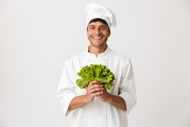 Gelukkig jonge chef-kok geïsoleerd op wit bedrijf salade.