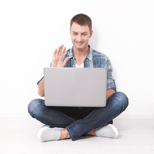 Gelukkig jonge man aan het werk op laptop