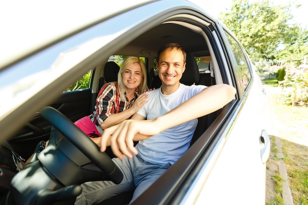 Gelukkig jonge man en vrouw in een auto genieten van een road trip op een zomerdag.