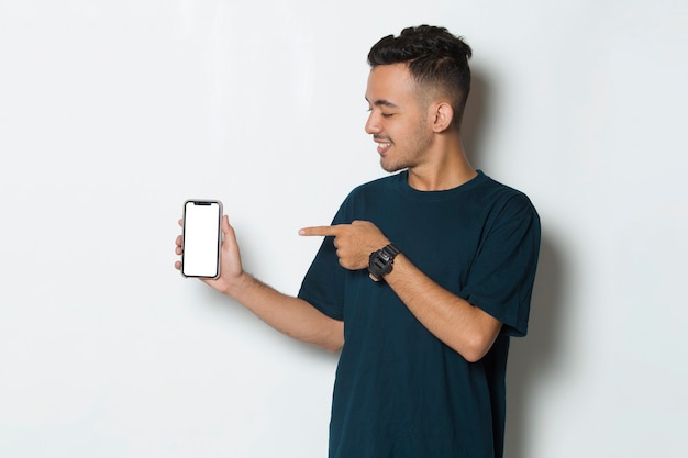 Gelukkig jonge man houdt mobiele telefoon met leeg leeg scherm geïsoleerd op witte achtergrond
