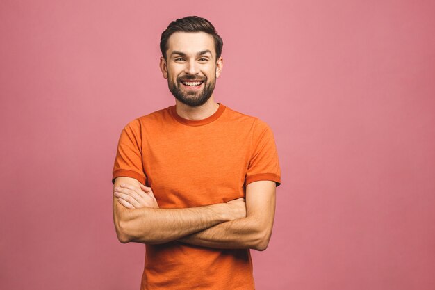 Gelukkig jonge man. Portret van de knappe jonge mens in toevallige gekruiste holdingswapens en glimlachend terwijl status.