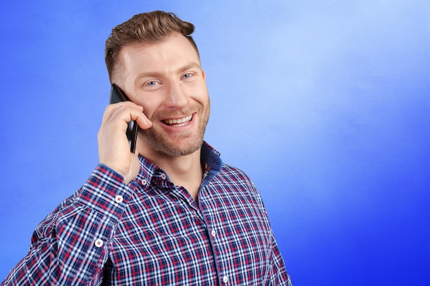 Gelukkig jonge man praten op mobiele telefoon