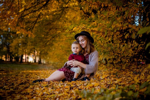 Gelukkig jonge moeder spelen met babyjongen in herfst park