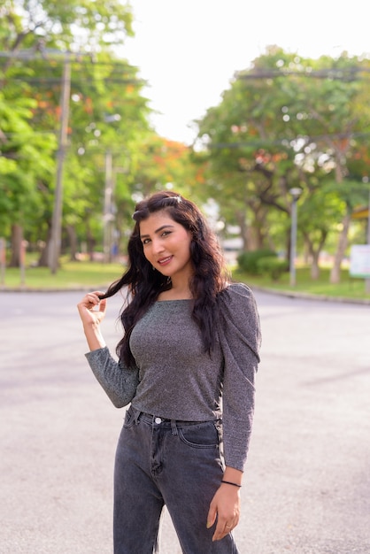 Gelukkig jonge mooie Indiase vrouw die lacht in de straten van het park