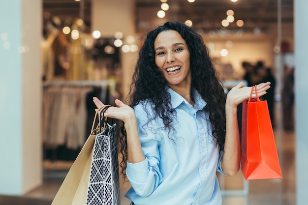 Gelukkig jonge mooie spaanse latijns-amerikaanse vrouw winkelen in een supermarkt houdt hij gekleurd papier