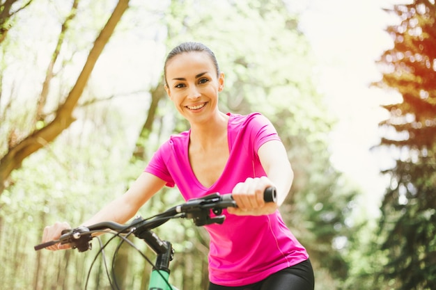 Gelukkig jonge mooie vrouw rijden Sport Mountaine fiets in bos buiten gezonde levensstijl Sport en Strong