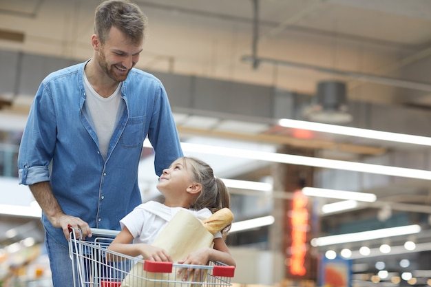 Gelukkig jonge vader in de supermarkt