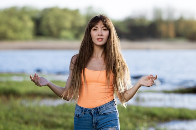 Gelukkig jonge vrouw dansen in koptelefoon op de oever van de zonnige lentedag van de baai zon