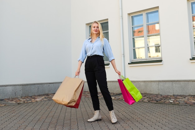 Gelukkig jonge vrouw met kleurrijke tassen na het winkelen