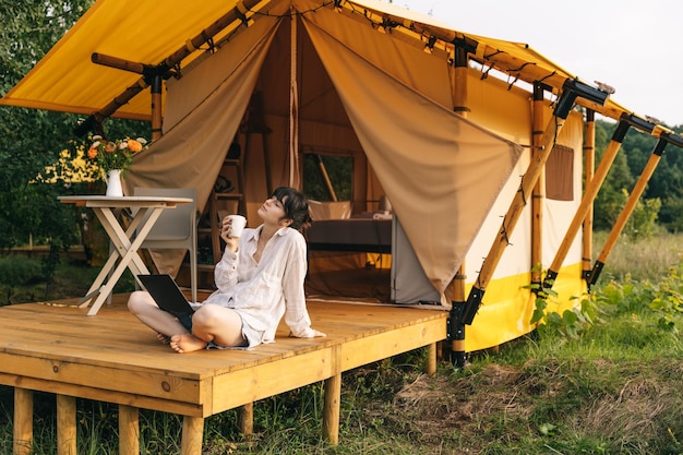 Gelukkig jonge vrouw toerist zittend in toeristische tent in de zomer